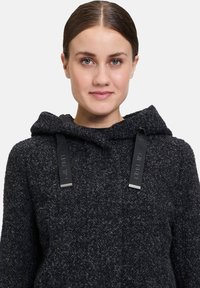 Czarny teksturowany sweter z kapturem o miękkim poczuciu, z regulowanymi paskami z srebrnym wykończeniem. Prosty, codzienny design z przytulnym wyglądem.