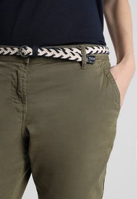 Olivgröna bomullsbukser med ett texturerat flätat bälte i marinblått och krämfärgat, med en sidficka och en avslappnad passform.