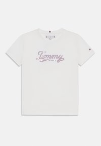 Biała bawełniana koszulka z krótkim rękawem z różowymi i niebieskimi cekinami w kształcie logo "Tommy". Okrągły dekolt i mały detal logo na rękawie.