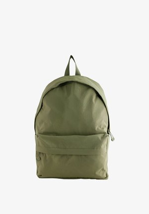 Zöld nejlon hátizsák lekerekített tetejével, cipzáras fő rekesszel, elülső zsebbel és egy felső akasztóhurkol. Simább textúrájú és minimális dizájnnal rendelkezik.