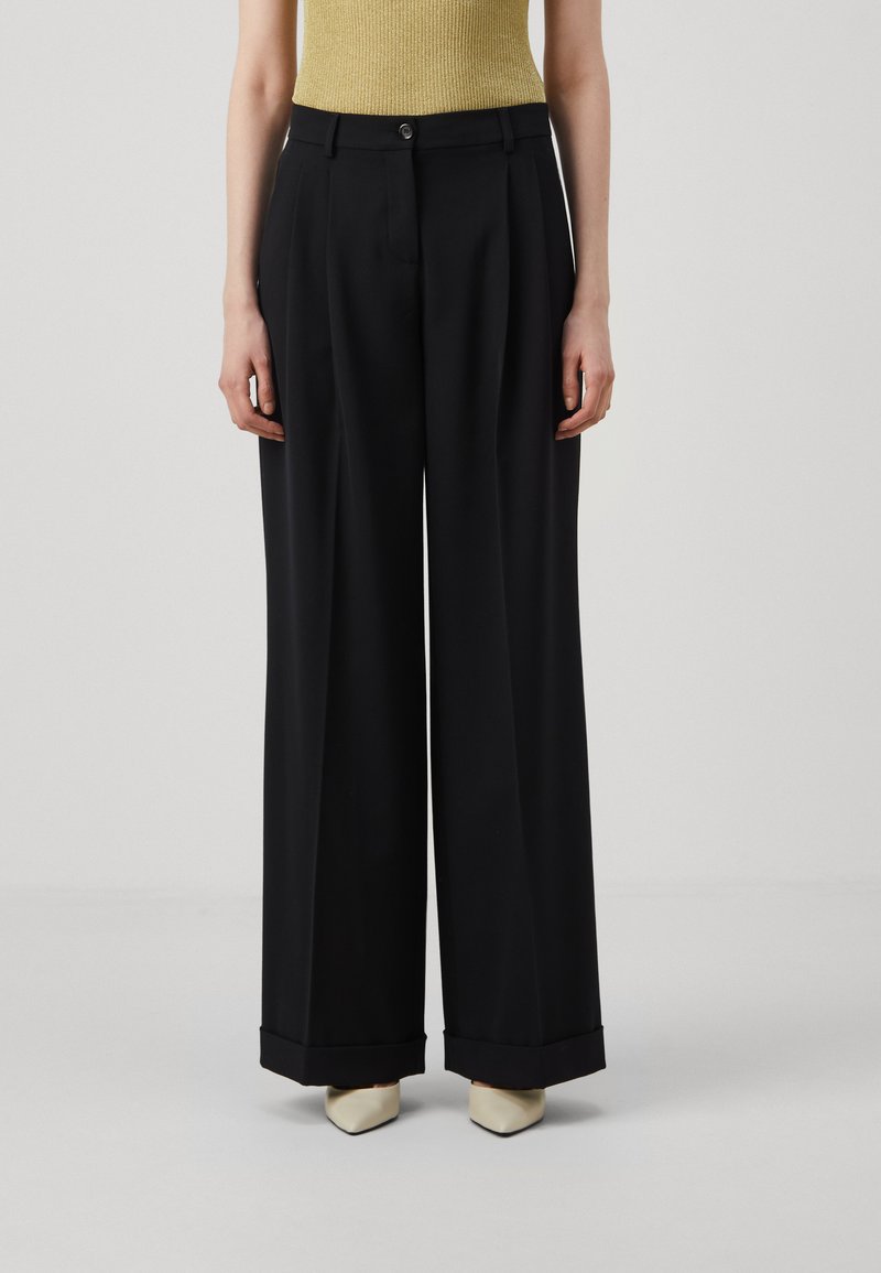 Zwarte wijde broek met hoge taille, voorzien van een knoopsluiting, plooien en opgerolde mouwen, gemaakt van een gladde stof.