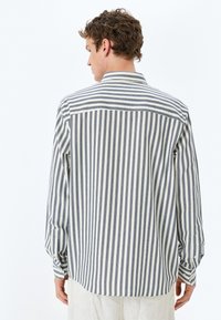Gestreepte langarmsgemouwen shirt in blauw en wit, met een button-down kraag, rugplooi en manchetten met knopen. Katoenmengsel.