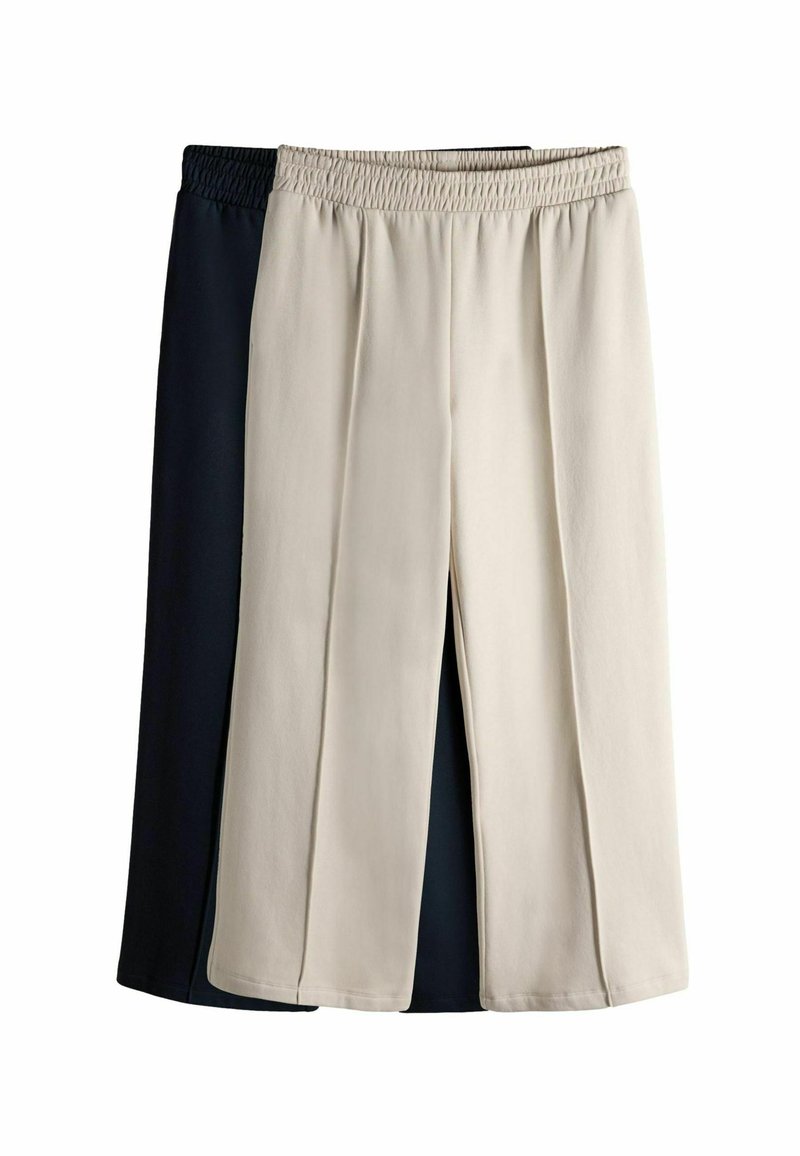 Zwei Paar weit geschnittene Hosen, eine in Creme und eine in Marineblau. Beide besitzen einen elastischen Bund und eine glatte Textur. Keine sichtbaren Muster.