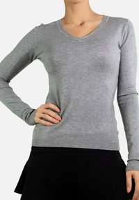 Pull gris à manches longues et en V en matériau doux, avec une coupe ajustée et des poignets et un ourlet côtelés pour plus de texture.