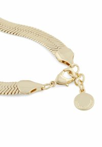 Halsband i guldfärgad metall med flexibla länkar, karbinlås och en rund berlock med ingraverad text. Slät yta och glänsande finish.