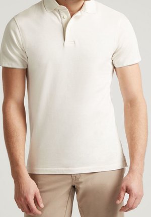 Kurzarm-Polohemd in Off-White, aus Baumwolle, mit klassischem Kragen, zwei Knopf-Leiste und subtiler Textur.