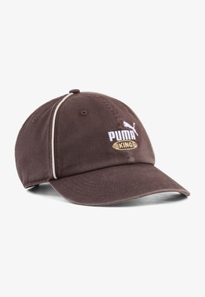 Casquette de baseball Puma King marron avec bordure blanche et logo brodé à l'avant, visière incurvée et œillets de ventilation sur les panneaux supérieurs.