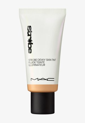 MAC Strobe Dewy Skin Tint i en hvit tube med svart skrift, beige bunn og svart lokk. Glatt tekstur, minimalistisk design.