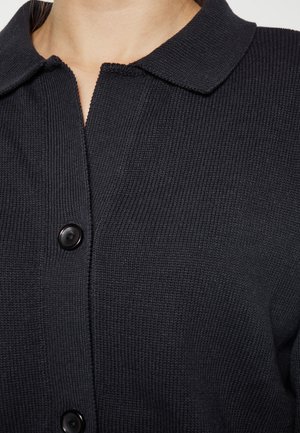 Dunkelblaues, knöpfbares Strick-Cardigan mit strukturiertem Rippendesign, ausgestattet mit einem Kragen und schwarzen Knöpfen entlang der Vorderseite.