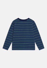 Dlouhý rukáv košile s námořnickými a světle zelenými vodorovnými pruhy, kulatým výstřihem a měkkým bavlněným materiálem s volným střihem.