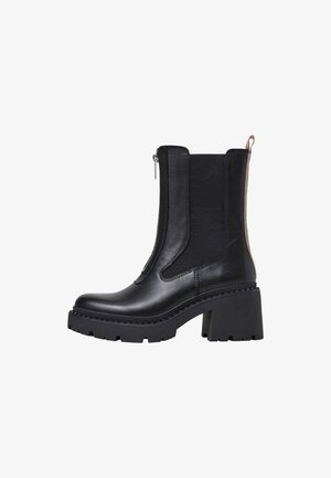 Black ankle boots featuring a smooth leather exterior, elastic side panels, a back zipper, and a thick, chunky heel with a tread sole.