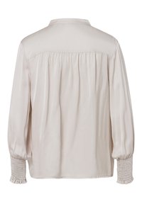 Cremefarbene Bluse mit langen Ärmeln und Knopfleiste am Kragen. Mit gerafftem Rücken und gesmokten Manschetten. Glatter, satinähnlicher Stoff mit sanftem Glanz.