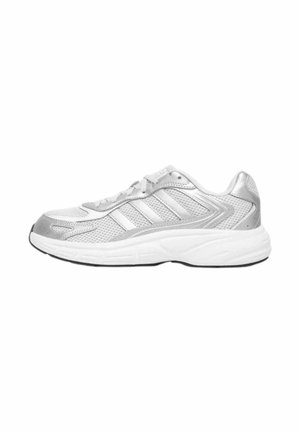 Zapatilla de correr plateada y blanca con parte superior de malla, superposiciones sintéticas, cierre de cordones y suela blanca acolchada, mostrada de lado sobre un fondo blanco.