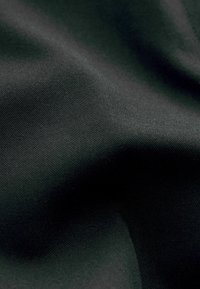Černá tkanina s hladkou texturou, mírným leskem a jemným vzorem tkaní. Materiál se zdá být lehký a pružný.