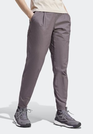 Gray, tapered pants with front pleats, side pockets, and a smooth texture. Paired with gray athletic shoes featuring textured accents.