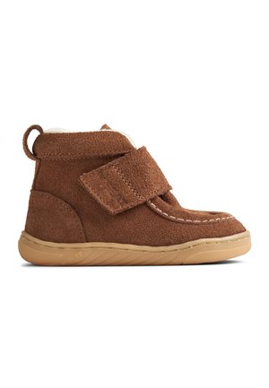 Brun ruskind børne støvle med beige gummisål, lukning med velcro og blødt hvidt foer synligt ved kraven.
