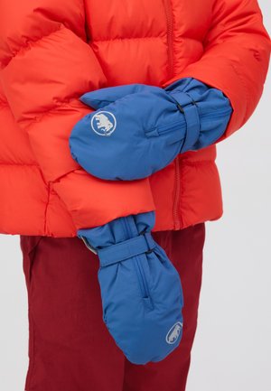Persona che indossa muffole imbottite blu e una giacca a piumino rossa con pantaloni rossi, mani incrociate in vita.