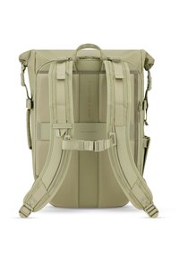 Zaino in khaki chiaro con spallacci regolabili, supporto dorsale imbottito e maniglia superiore. Presenta dettagli con logo e numerose tasche con zip.