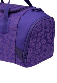 Purple duffel bag featuring a unique pattern of abstract shapes. Made of durable fabric with a smooth zipper and sturdy carrying straps.