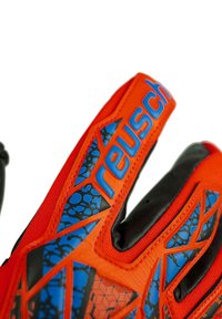Primo piano delle dita dei guanti da portiere Reusch arancioni e neri con motivi geometrici e texture blu.