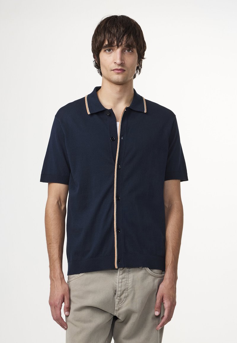 Marineblaues Kurzarm-Polohemd aus weichem Stoff, mit Knopfverschluss, kontrastierenden beigen Akzenten und einem klassischen Kragen-Design.