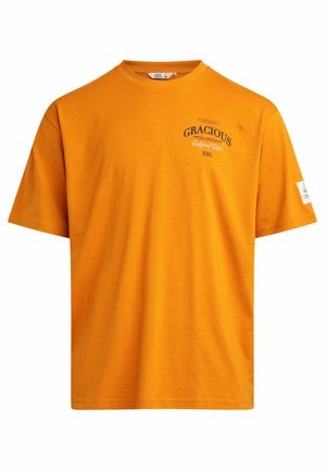 Orange cotton t-shirt with short sleeves, round neck, and printed text. Features a tag on the left sleeve and a straight hemline.