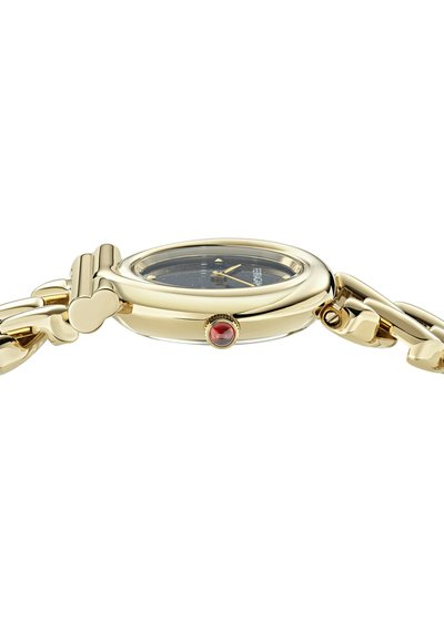 Zlatem tónovaný náramkový hodinky s kulatým pouzdrem, tmavě modrým ciferníkem a stříbrnými akcenty. Má jemně texturovaný náramek a červený kamenný detail.