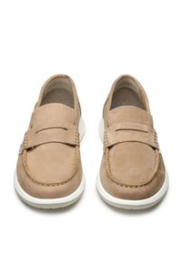 Mocassini in suede beige con un design cucito, suola piatta bianca e punta arrotondata. Presentano una piccola cinghia superiore e accenti minimi.