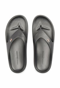 Para czarnych klapek Tommy Hilfiger z teksturowanymi wkładkami i plakietkami z logo na ramiączkach, na białym tle.
