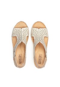 Sandali in pelle perforata beige con design a due parti, punta e tallone aperti, caratterizzati da dettagli intrecciati lungo la suola e una soletta con marchio.