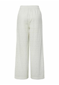 Pantalons à jambes larges en tissu broderie anglaise de couleur claire, avec une taille élastique et de petits motifs circulaires partout.