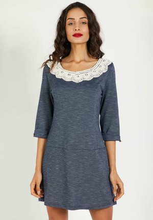 Vestido de color navy con mangas tres cuartos, que presenta un cuello de encaje blanco y un cuerpo ajustado. Hecho de un tejido suave y texturizado.