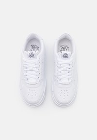 Sneakers bianchi in pelle con punta arrotondata, dettagli perforati, lacci bianchi piatti e un logo grafico all'interno. Design classico a basso profilo.