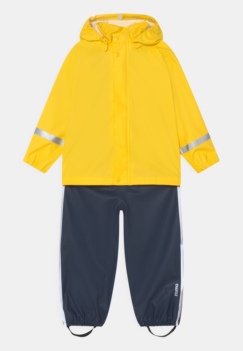 Gele waterdichte regenjas met een capuchon en zilveren reflecterende strips, gecombineerd met marineblauwe waterdichte broek met witte zijstrepen.