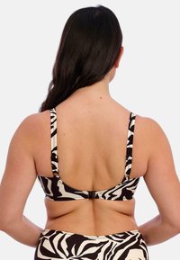 Bikini top s černobílým vzorem, tenkými nastavitelnými ramínky a háčkovým zapínáním na zádech, vyrobený z hladkého a elastického materiálu.