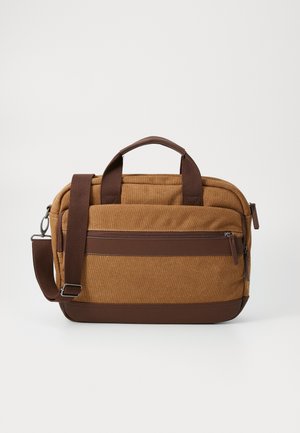 Serviette marron en toile et cuir avec doubles poignées, poche avant zippée et bandoulière réglable sur un fond uni.