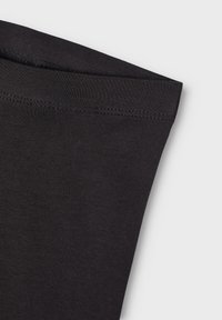 Zwarte katoenen T-shirt detail dat de soepele stoftextuur, de rand van de halslijn en zichtbare stiksels toont. De stof is rekbaar en aansluitend.