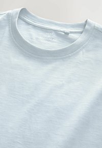 Lyseblå t-shirt i bomuld med rund hals, normal pasform og en glat overflade. Mærkninger inkluderer størrelse og oprindelsesland.