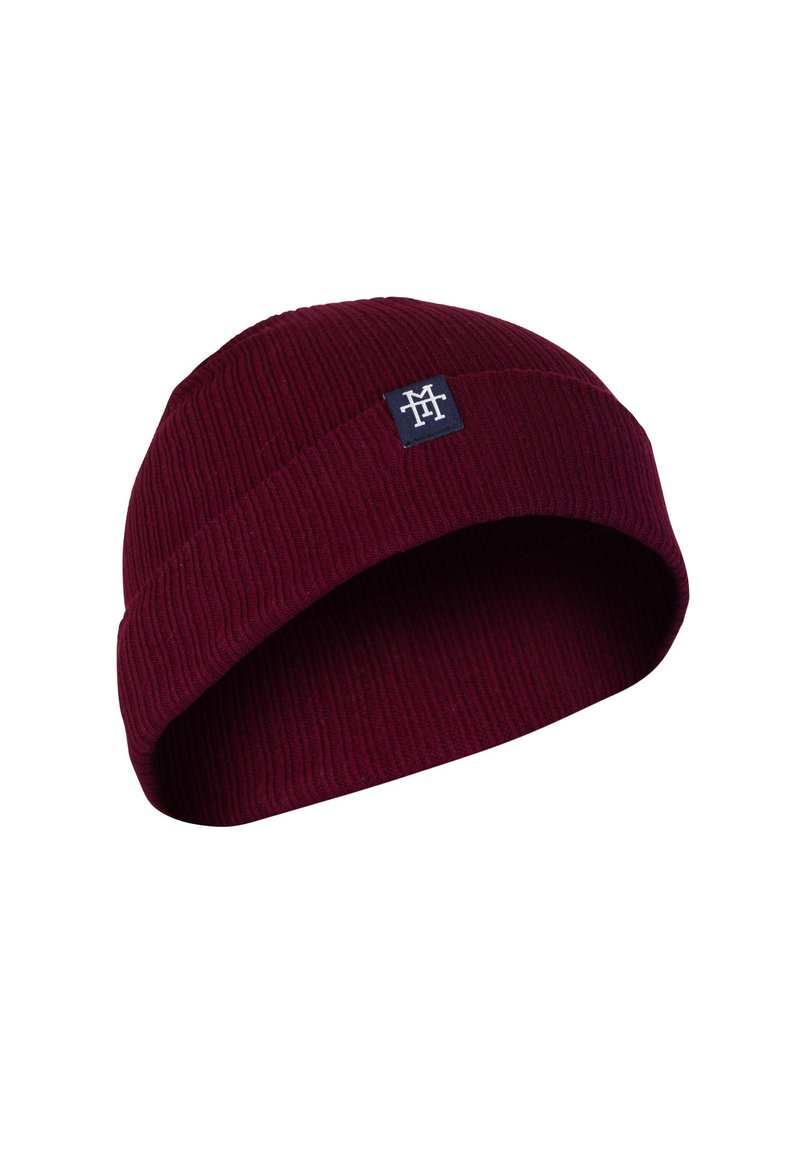 Burgundy knit beanie with ribbed texture, folded brim, and a small square logo patch in dark blue on the front.
