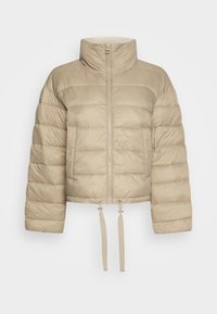 Beige pufferjacka med hög krage, framsida med dragkedja och elastisk nederkant. Har subtil horisontell quilting och justerbara dragsnören.