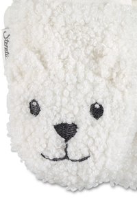 Weißer Plüschsocken mit einer strukturierten, flauschigen Oberfläche. Besondere Merkmale sind ein Bärenkopf mit gestickten schwarzen Augen, einer Nase und einem Mund.