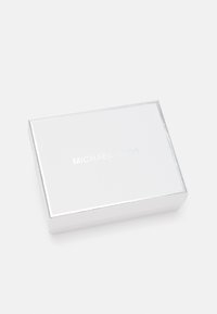 Scatola regalo Michael Kors, forma rettangolare, materiale bianco lucido, dettagli argentati, logo in rilievo sulla parte superiore, superficie liscia.