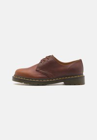 Braunes Leder-Schuh mit glatter Oberfläche, runder Zehenform und fünf Ösen-Schnürung. Verfügt über gelbe Nähte entlang der Sohle und eine strukturierte Ferse.