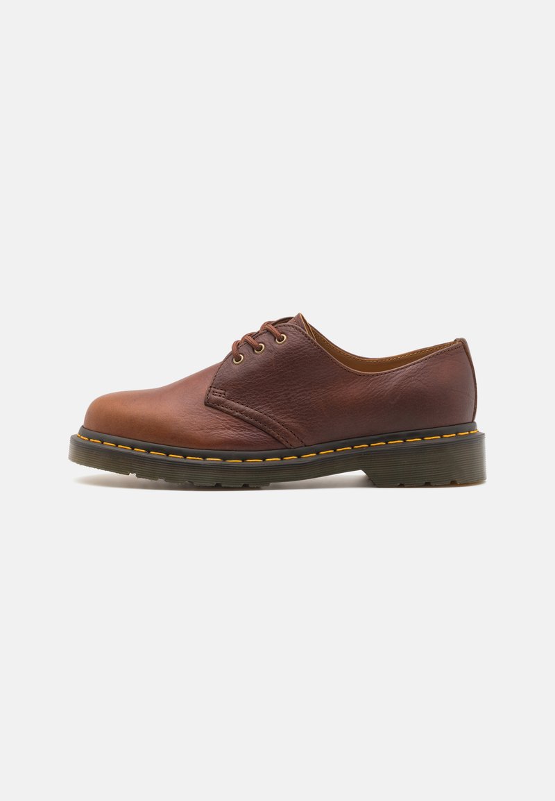Braunes Leder-Schuh mit glatter Oberfläche, runder Zehenform und fünf Ösen-Schnürung. Verfügt über gelbe Nähte entlang der Sohle und eine strukturierte Ferse.