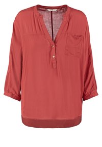 Blouse à manches longues couleur rouille avec col en V, deux boutons sur le devant et une poche poitrine, confectionnée en tissu léger légèrement brillant.