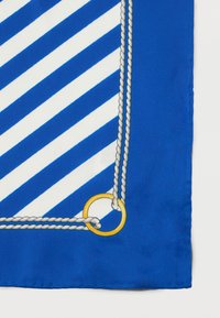 Γωνία από ύφασμα με μπλε και λευκές ρίγες, με μοτίβο περίσφιξης σχοινιού και χρυσό δαχτυλίδι σε λευκό φόντο.