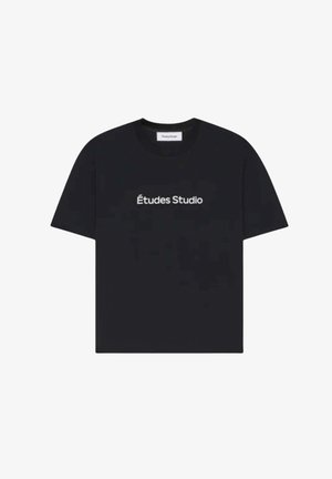 T-shirt noir à manches courtes et col rond avec l'inscription "Études Studio" imprimée en blanc, centrée sur le devant.
