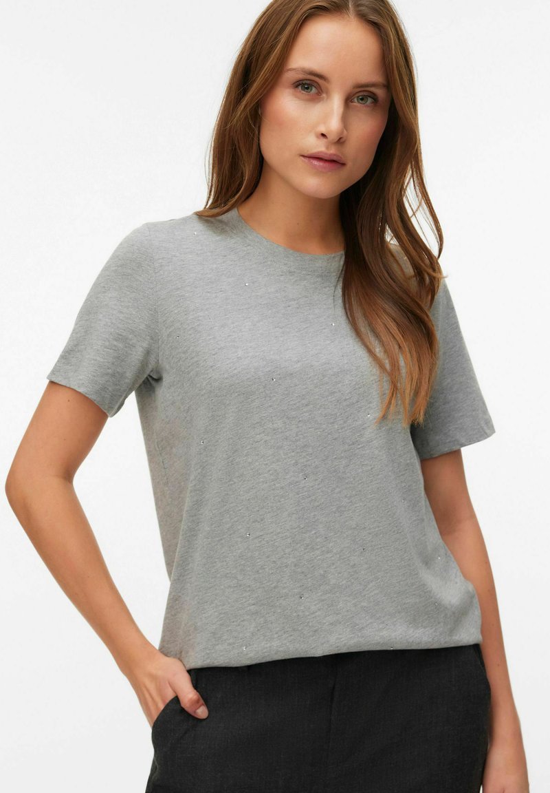 Maglietta grigia a maniche corte realizzata in materiale morbido, con un classico scollo rotondo e piccoli dettagli decorativi sulla parte frontale.