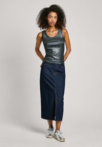 Top in cotone grigio scuro lucido abbinato a una gonna midi in denim scuro a vita alta con spacco frontale, completato da sneakers argentate.