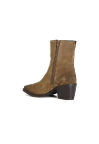 Botas de tobillo de ante marrón con punta afilada, cremallera lateral y tacón bajo en bloque. La textura es suave, con sutiles acentos de costura.
